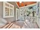 Outdoor porch with a ceiling fan, wood floors and porch railings surrounded by many trees at 87 Dungannon Hall, Kiawah Island, SC 29455