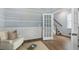 Comfortable sitting room featuring hardwood floors, wainscoting, and a stylish accent wall at 1014 Swamp Rose Run, Summerville, SC 29485