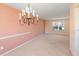 Open-concept dining room with neutral walls, carpet flooring, and chandelier at 1051 Wayfarer Ln, Charleston, SC 29412