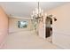 Light-filled dining room with chandelier, carpet, and view of backyard at 1051 Wayfarer Ln, Charleston, SC 29412