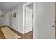 Hallway featuring hardwood floors, a white door and neutral colored walls with paintings at 108 Gambels Ln, Summerville, SC 29485