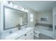 Bright bathroom featuring a double sink vanity with marble countertops, a soaking tub, and neutral décor at 1089 Fort Johnson Rd, Charleston, SC 29412