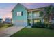 Charming two-story home featuring a light teal exterior, a welcoming porch, and a well-manicured lawn at 1089 Fort Johnson Rd, Charleston, SC 29412
