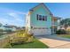 Attractive two-story home showcases a light teal exterior, a spacious garage, and a lovely landscaped front yard at 1089 Fort Johnson Rd, Charleston, SC 29412