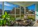 Relaxing screened-in porch featuring cozy furniture, a ceiling fan, and picturesque views of the backyard at 1089 Fort Johnson Rd, Charleston, SC 29412