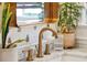 Bathroom with a copper faucet, white marble countertop, and potted plants at 12 Poplar St, Charleston, SC 29403