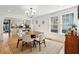 Light-filled dining room adjacent to an open kitchen featuring hardwood floors and neutral decor at 12 Poplar St, Charleston, SC 29403