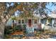 Charming home featuring a cozy front porch, brick accents, and mature trees at 12 Poplar St, Charleston, SC 29403