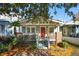 Charming home with mature landscaping, front porch, brick accents, and bright red front door at 12 Poplar St, Charleston, SC 29403