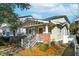 Street view of inviting home featuring a landscaped yard, front porch, and eye-catching brick foundation at 12 Poplar St, Charleston, SC 29403