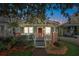 Charming home featuring a cozy front porch, brick accents, and mature trees at 12 Poplar St, Charleston, SC 29403