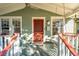 Cozy front porch with swing, ceiling fan, and bright red door for relaxing outdoors at 12 Poplar St, Charleston, SC 29403