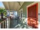 Welcoming front porch with an orange door, offering a cozy outdoor space for relaxation at 12 Poplar St, Charleston, SC 29403