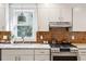 Bright kitchen with stainless steel appliances, light cabinets, and tile backsplash at 12 Poplar St, Charleston, SC 29403