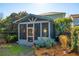 Outdoor screened-in porch with orange door, backyard view, and lush landscaping at 12 Poplar St, Charleston, SC 29403