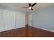 Bedroom with hardwood floors, a ceiling fan, closet doors, and an open door to the house at 1239 Wappetaw Pl, Mount Pleasant, SC 29464