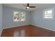 Bright bedroom featuring hardwood floors, a ceiling fan, and two windows providing natural light at 1239 Wappetaw Pl, Mount Pleasant, SC 29464