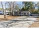 Home's driveway and landscaping with mature trees on a sunny day at 1239 Wappetaw Pl, Mount Pleasant, SC 29464