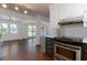 Open kitchen with stainless steel appliances and an open view into the living room with large bright windows at 1239 Wappetaw Pl, Mount Pleasant, SC 29464
