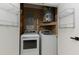 Well-organized laundry area with washer, dryer, and shelving for easy access at 1239 Wappetaw Pl, Mount Pleasant, SC 29464