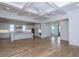 Open-concept living space featuring hardwood floors, coffered ceiling, and a view of the kitchen at 1468 Alligator Creek Ct, Awendaw, SC 29429