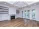 Living room with a fireplace, built-in shelving, coffered ceiling, and access to the patio at 1468 Alligator Creek Ct, Awendaw, SC 29429