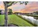 Scenic backyard view of landscaped lawn, pond and view of neighboring houses during sunset at 174 Sea Lavender Ln, Summerville, SC 29486