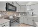 Close-up of a modern kitchen with gray cabinets, stainless steel appliances, and decorative tile backsplash at 174 Sea Lavender Ln, Summerville, SC 29486