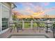 Covered patio with iron furniture featuring sunset views of community pond, fence and manicured lawns at 174 Sea Lavender Ln, Summerville, SC 29486