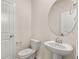 Stylish half-bathroom with a pedestal sink, oval mirror, and modern fixtures, adjacent to a door at 1832 Nola Run, Summerville, SC 29485