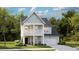 Charming two-story home with front porch, manicured lawn, attached garage, and lush surrounding trees at 1844 Nola Run, Summerville, SC 29485