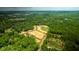 Community aerial view with a scenic pond, lush green trees, and newly constructed roads at 201 Seele St, Lincolnville, SC 29485