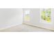 Bright bedroom with natural light, complemented by two windows that overlook the surrounding outdoor greenery at 201 Seele St, Lincolnville, SC 29485