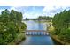 Scenic aerial view of a wooden bridge connecting lush green landscapes over a tranquil lake at 207 Calm Water Way, Summerville, SC 29486