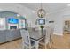Bright dining area featuring wood floors, vaulted ceilings, a decorative chandelier, and a gray farmhouse dining set at 207 Calm Water Way, Summerville, SC 29486