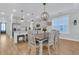 Dining area features a wooden table, chairs, and modern lighting near the open kitchen at 207 Calm Water Way, Summerville, SC 29486