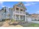 Stylish two-story home with a spacious second-story balcony, porch, and well-manicured lawn at 207 Calm Water Way, Summerville, SC 29486