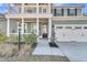 Inviting front entry with a black front door, white columns, and a two-car garage at 207 Calm Water Way, Summerville, SC 29486