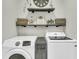 Well-lit laundry room featuring modern washer and dryer, decorative shelves, and stylish decor at 207 Calm Water Way, Summerville, SC 29486