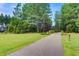 A community walking path is flanked by green grass and mature pine trees at 207 Calm Water Way, Summerville, SC 29486