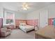 Charming bedroom featuring pink wainscoting, ceiling fan, and a bright window with neighborhood views at 217 Lucca Dr, Summerville, SC 29486