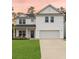 Charming two-story home featuring a spacious garage, well-maintained lawn, and inviting front porch with seating at 217 Lucca Dr, Summerville, SC 29486