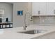 Close up of the kitchen sink and faucet, featuring quartz countertops and grey tile backsplash at 217 Lucca Dr, Summerville, SC 29486