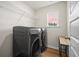 Efficient laundry room equipped with modern washer and dryer, and overhead shelving at 217 Lucca Dr, Summerville, SC 29486