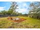 Backyard with well-kept lawn, fence, fire pit and wooden Adirondack chairs at 231 Bayview Dr, Mount Pleasant, SC 29464