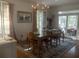 Bright dining room featuring a chandelier, shuttered windows, and access to an outdoor patio at 24 Commons Ct, Isle of Palms, SC 29451