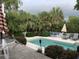 Relaxing pool area with lounge seating, umbrellas, and privacy fencing amidst palm trees at 24 Commons Ct, Isle of Palms, SC 29451