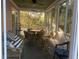 Relaxing screened porch with wicker furniture and a ceiling fan, perfect for enjoying the outdoors at 24 Commons Ct, Isle of Palms, SC 29451