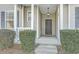 Front door featuring an elegant overhead light fixture, dark door, white railing, and large bushes at 249 Brookshire Rd, Goose Creek, SC 29445