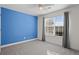 Bright bedroom featuring a striking blue accent wall, large window, and neutral carpet at 322 Equinox Cir, Ladson, SC 29456